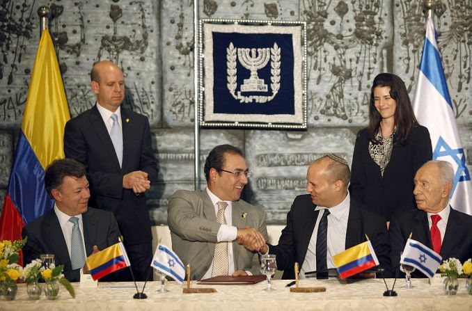 Naftali Bennet, entonces ministro de Industria, Comercio y Trabajo, estrecha la mano del ministro de Trabajo de Colombia Sergio Díaz, en un encuentro el 10 de junio de 2013 para firmar un acuerdo económico.