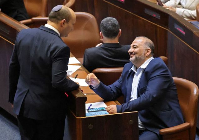 Bennett, líder del partido Yamina, dialoga con Mansour Abbas, del partido conservador islámico Raam, en una sesión del Knéset del 13 de junio de 2021. Ambos son parte de la coalición que logró destronar a Netanyahu.