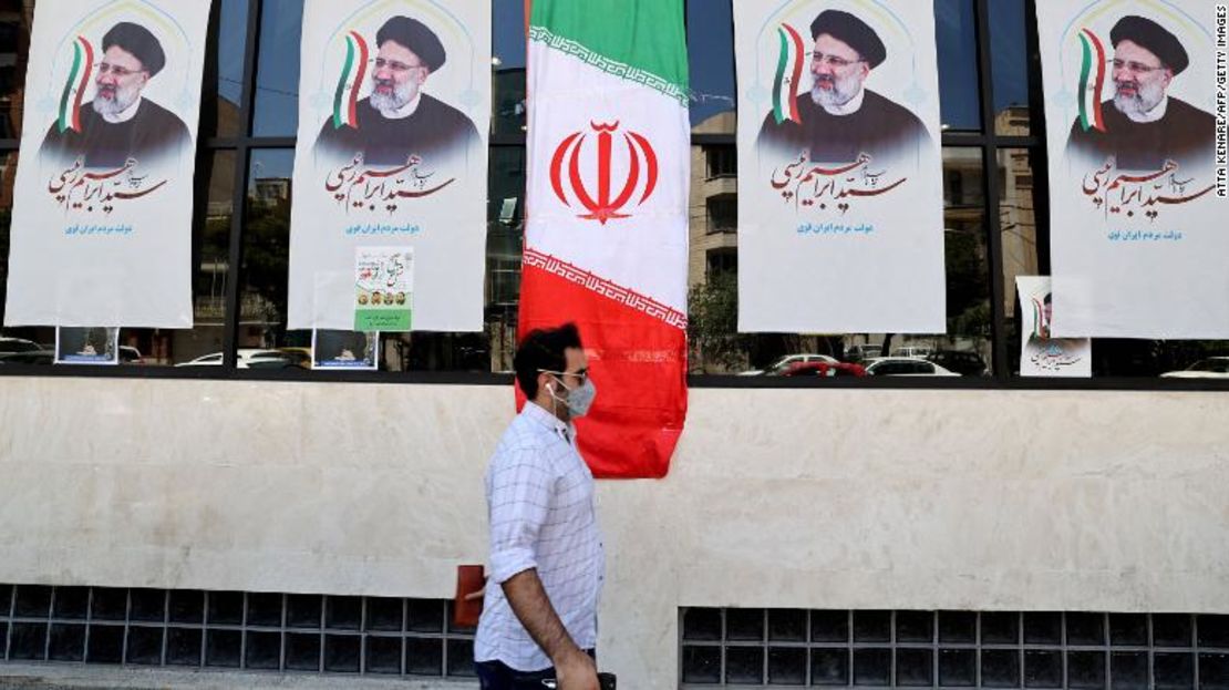 Un hombre iraní camina junto a carteles de Raisi frente a una oficina de campaña en Teherán el 7 de junio.