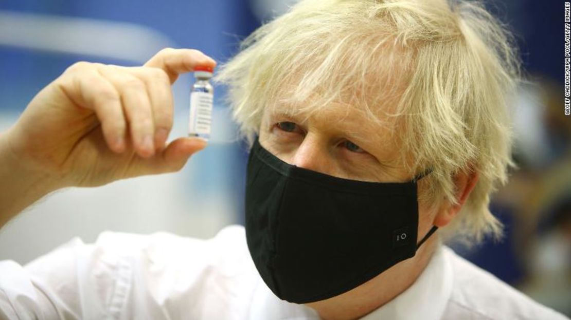 El primer ministro británico, Boris Johnson, posa con un vial de la vacuna de Oxford/AstraZeneca durante una visita al centro de vacunación del estadio de Cwmbran el 17 de febrero de 2021 en Cwmbran, Gales.