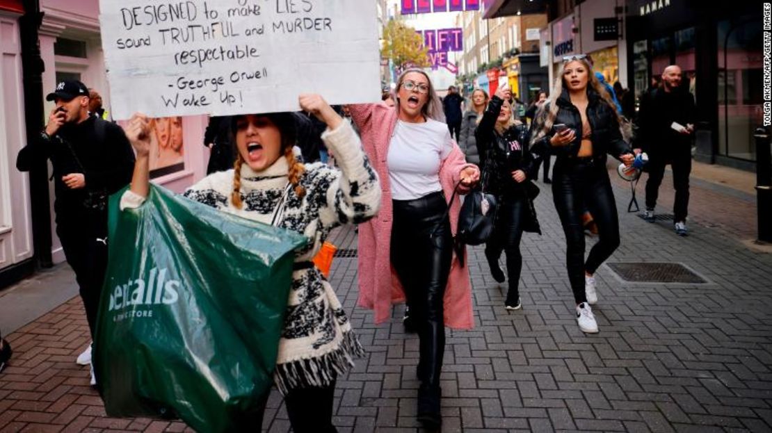 Manifestantes sostienen pancartas mientras participan en una protesta contra las restricciones gubernamentales diseñadas para controlar o mitigar la propagación del nuevo coronavirus, incluyendo el uso de mascarillas y cierres, en Londres el 28 de noviembre de 2020.