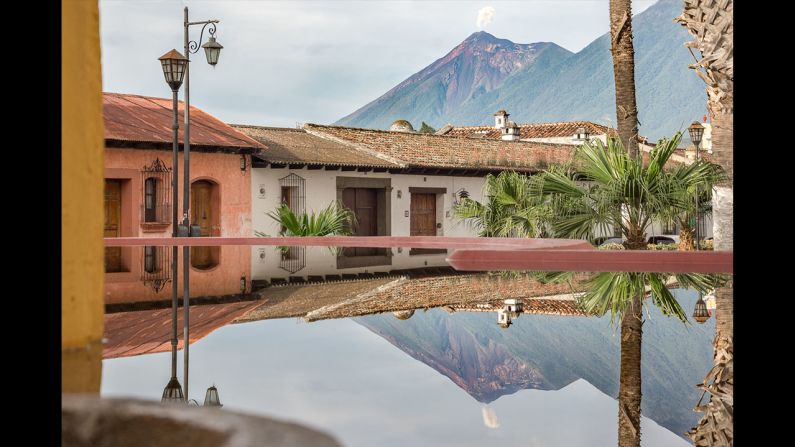 Reflejo del volcán de Fuego en el lavadero público de la ciudad colonial de Antigua, Guatemala.