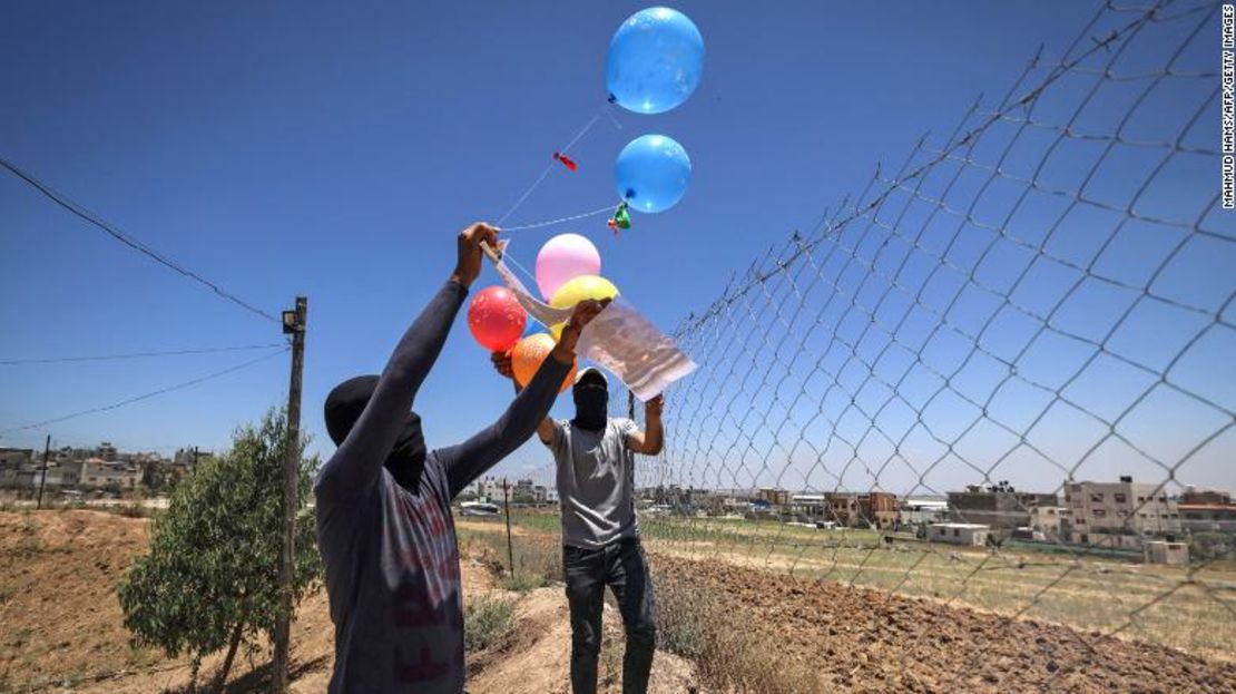 Militantes palestinos enmascarados del movimiento de la Yihad Islámica preparan globos incendiarios este martes.