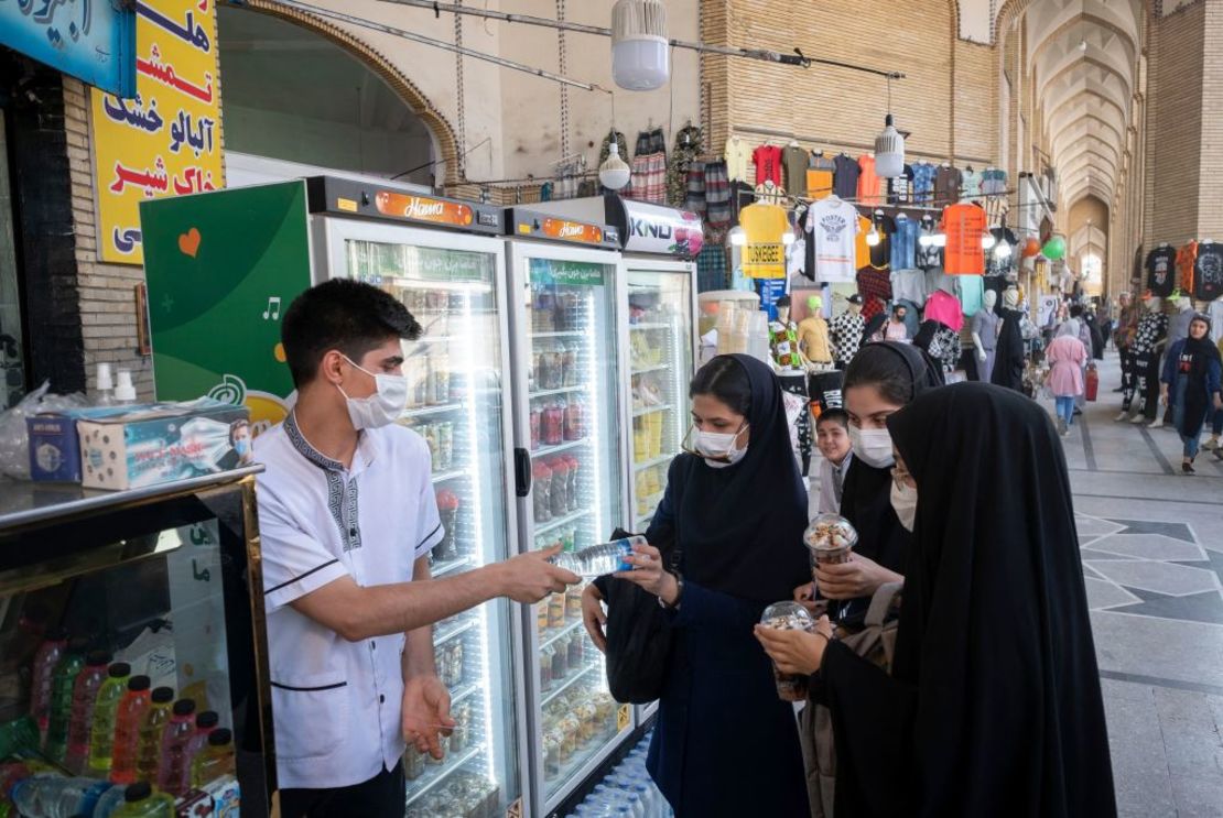 Jóvenes iraníes compran dulces en las calles de Teherán, capital iraní, el 16 de junio de 2021
