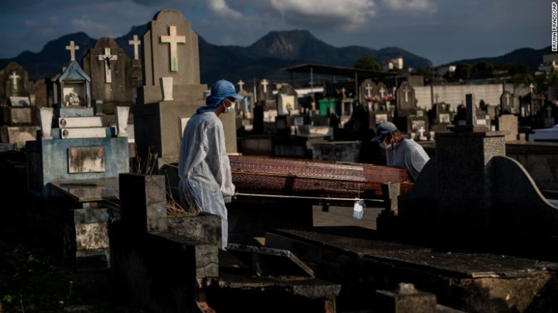 Los trabajadores del cementerio llevan el ataúd de una persona que murió por complicaciones relacionadas con el covid-19 en el cementerio Inhauma en Río de Janeiro, Brasil, el 18 de junio de 2021.