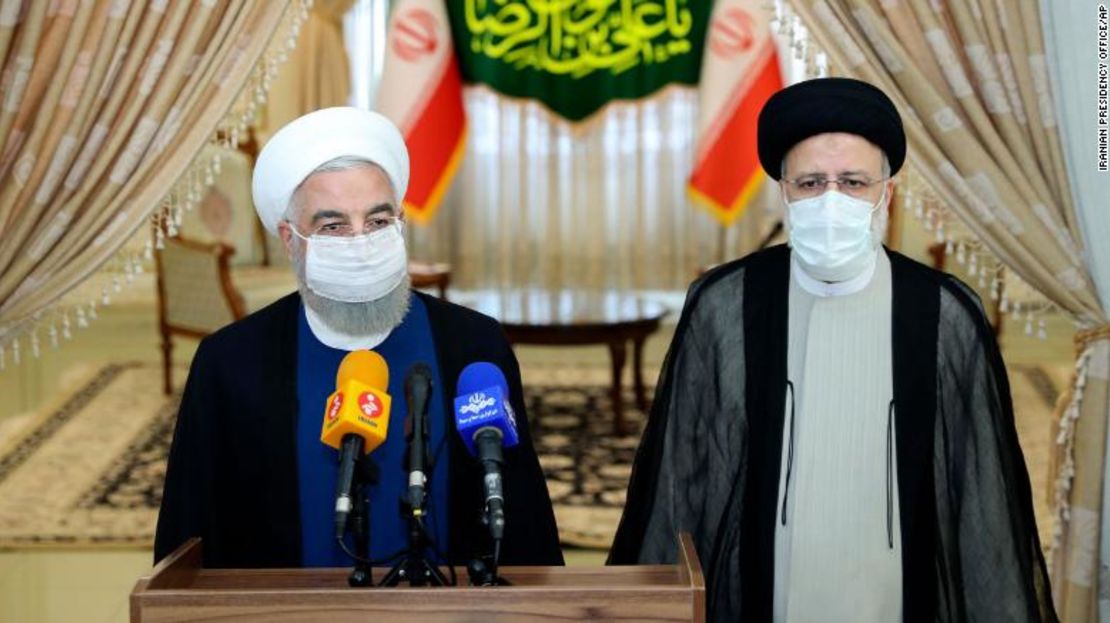 En esta foto publicada por el sitio web oficial de la oficina de la Presidencia de Irán, el presidente Hassan Rouhani, a la izquierda, habla con los medios de comunicación después de su reunión con el presidente electo Ebrahim Raisi, a la derecha, que es el actual jefe del poder judicial, en Teherán, Irán, el sábado 19 de junio de 2021.