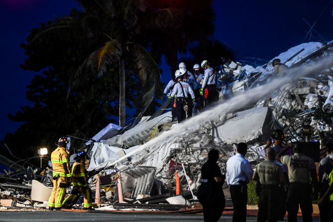El personal de búsqueda y rescate trabaja en el edificio parcialmente colapsado durante la noche del 24 de junio de 2021. Crédito: CHANDAN KHANNA / AFP vía Getty Images