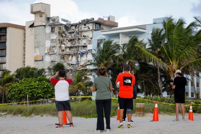 La gente observa los restos del edificio derrumbado en Surfside al norte de Miami Beach, Florida, el 25 de junio de 2021. Crédito: EVA MARIE UZCATEGUI / AFP a través de Getty Images
