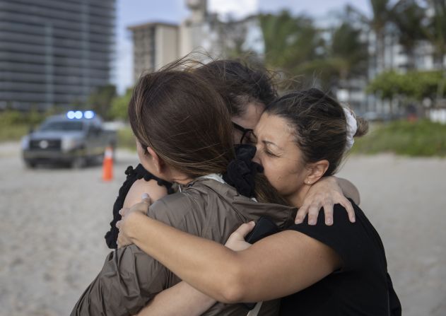 María Fernanda Martínez, Fayzah Bushnaq y Mariana Cordeiro se abrazan cerca de donde continúan las operaciones de búsqueda y rescate. Crédito: Joe Raedle / Getty Images