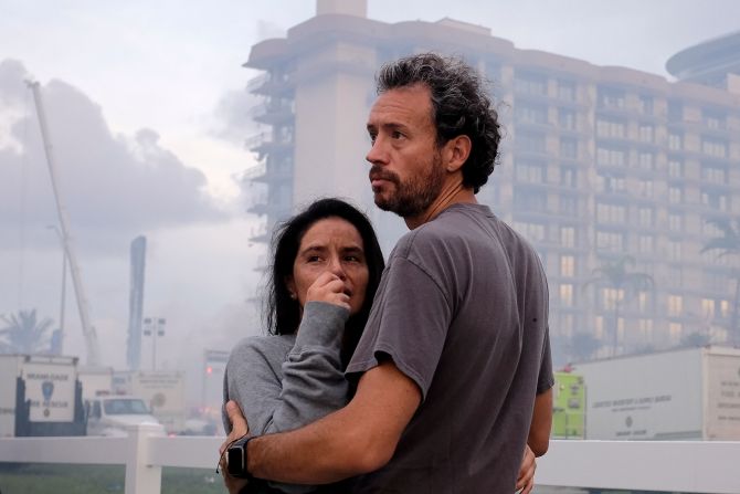 Una pareja se abraza mientras miran los escombros del edificio parcialmente derrumbado. Crédito: MARCO BELLO / AFP via Getty Images