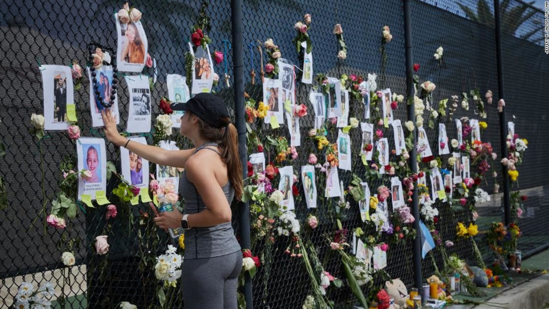 Residentes, amigos y familiares visitan el muro conmemorativo de fotos y flores para los desaparecidos cerca del sitio del colapso.