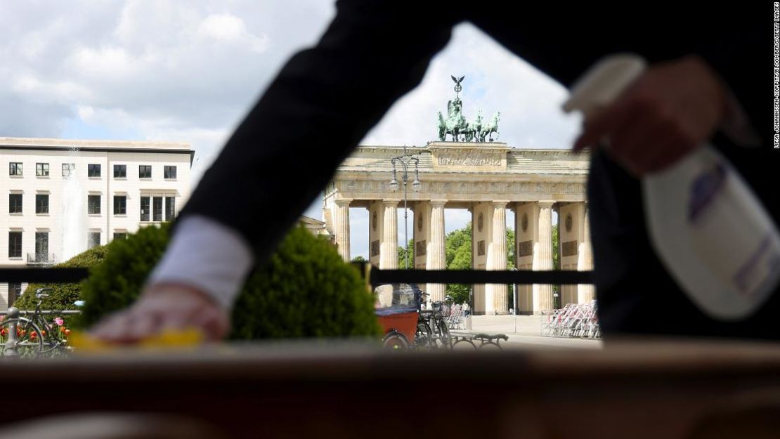 Un camarero limpia la mesa de un restaurante antes de la reapertura en Berlín, Alemania, el 21 de mayo de 2021.