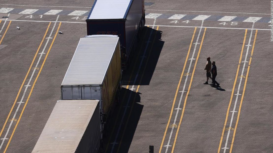 Los conductores de camiones cruzan un estacionamiento de camiones de transporte en el puerto de Dover el 1 de junio de 2021. Casi un tercio de las empresas de logística del Reino Unido esperan enfrentar escasez de camiones este año, y el 10% dice que los problemas de contratación representan una "barrera extrema" para la recuperación de la pandemia.