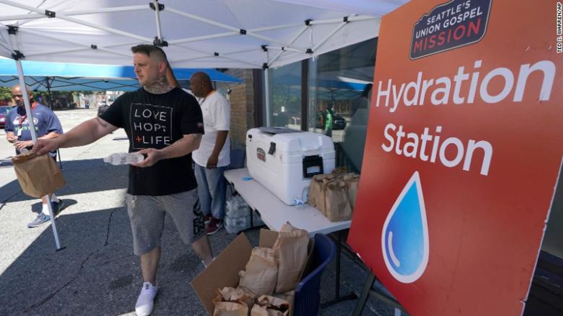 Carlos Ramos reparte botellas de agua y almuerza el lunes en una estación de hidratación frente a Union Gospel Mission en Seattle.