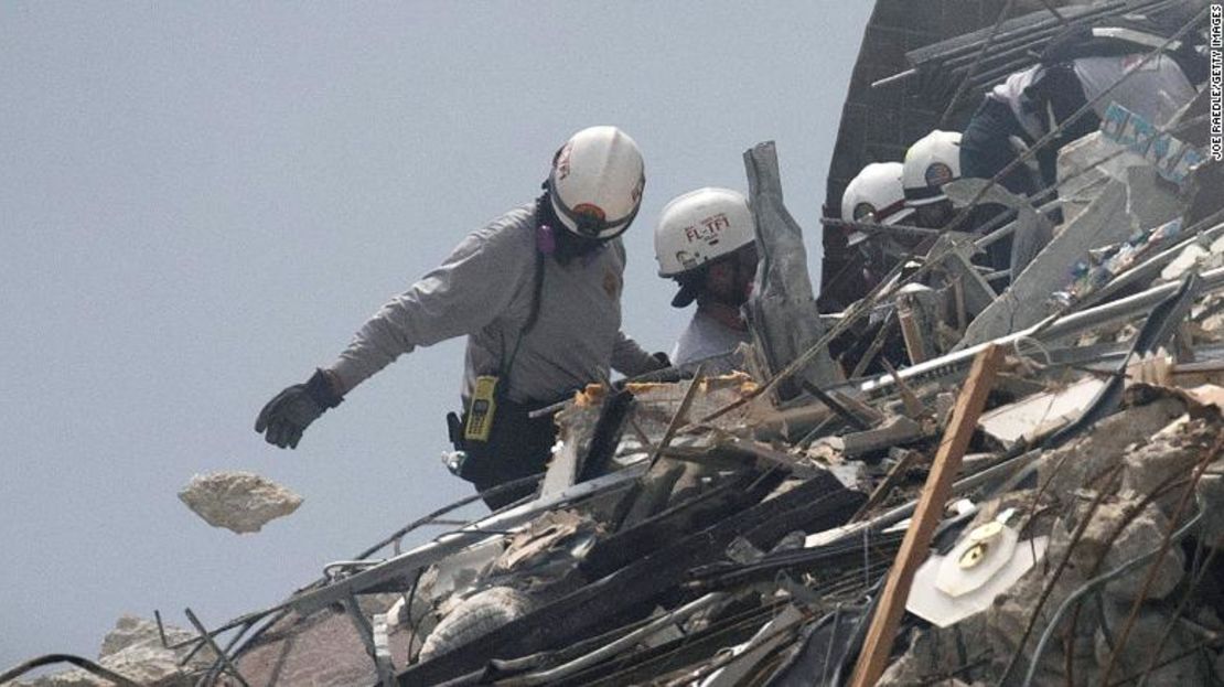 Equipos de bomberos de Miami-Dade registran el montón de escombros el viernes.