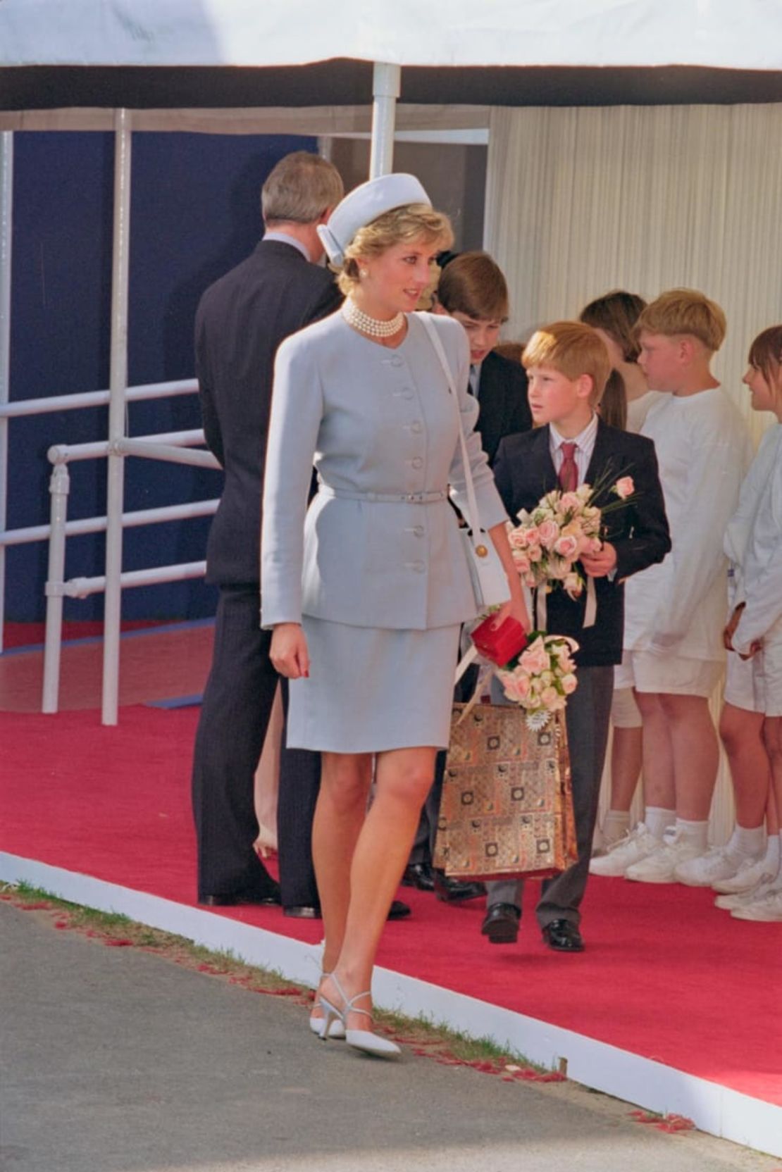 La princesa Diana con un traje azul claro y un sombrero tipo pillbox en 1995, acompañada de su hijo el príncipe Harry. Crédito: Princess Diana Archive/Hulton Archive/Getty Images