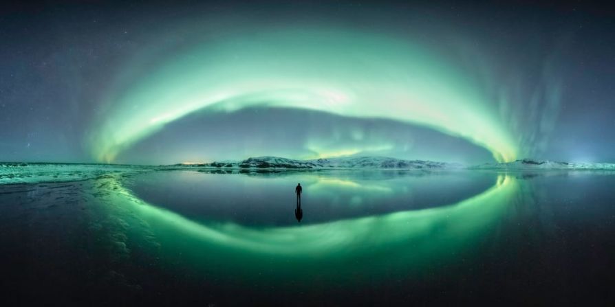 En este panorama de la aurora boreal en Islandia, el fotógrafo se encontró con este estuario que reflejaba perfectamente el cielo en una noche de invierno. Primero capturó el panorama y luego tomó una foto de sí mismo en el hielo. Larryn Stuart Rae