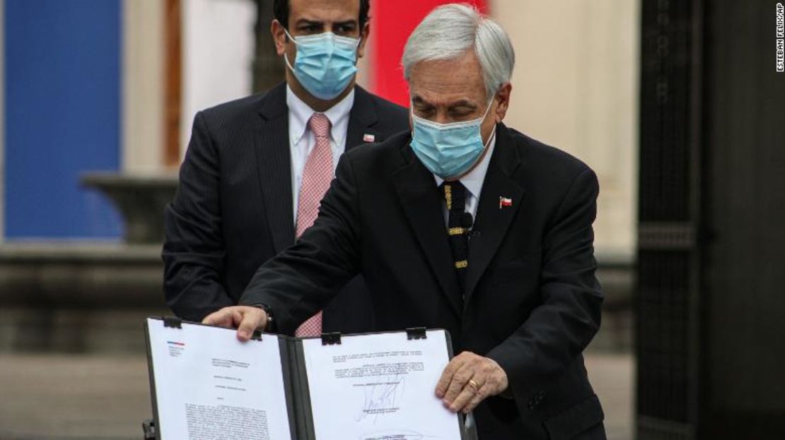 El presidente de Chile, Sebastián Piñera, muestra el documento oficial que llama a los miembros de la asamblea que redactarán una nueva constitución a reunirse para su primera sesión el 4 de julio, en el palacio presidencial de La Moneda en Santiago, Chile, el domingo 20 de junio de 2021.