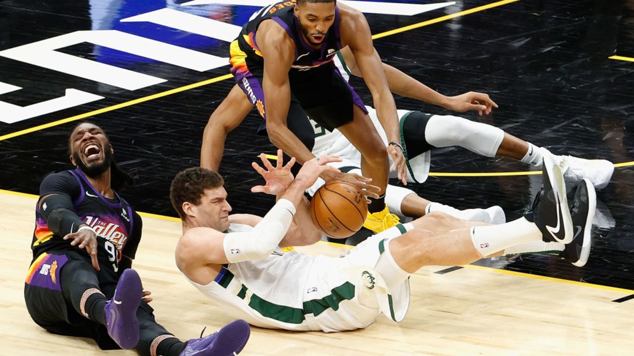 PHOENIX, ARIZONA - FEBRUARY 10: Brook Lopez #11 of the Milwaukee Bucks and Mikal Bridges #25 of the Phoenix Suns battle for a loose ball during the second half of the NBA game at Phoenix Suns Arena on February 10, 2021 in Phoenix, Arizona.   The Suns defeated the Bucks 125-124. NOTE TO USER: User expressly acknowledges and agrees that, by downloading and or using this photograph, User is consenting to the terms and conditions of the Getty Images License Agreement.