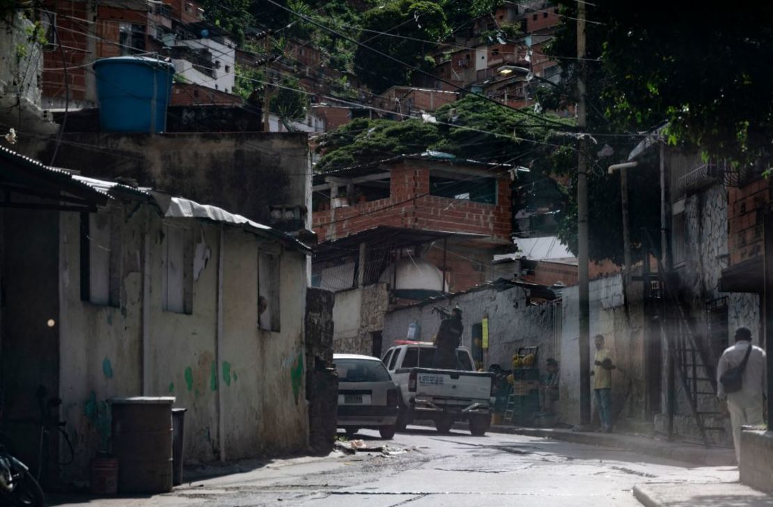 Un miembro del Cuerpo de Investigaciones Científicas, Penales y Criminalísticas (CICPC) apunta con su arma mientras entra en el barrio de El Valle en las inmediaciones de la Cota 905, durante los enfrentamientos contra presuntos miembros de una banda criminal en Caracas, el 8 de julio de 2021.