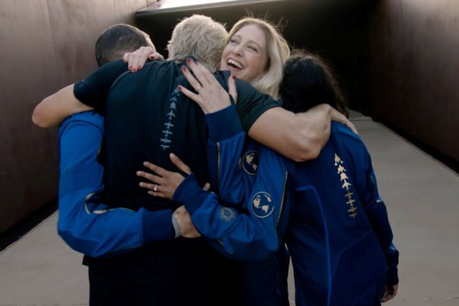 La instructora jefe de astronautas de Virgin Galactic, Beth Moses, abraza a Branson y a otros de la tripulación antes del vuelo espacial.