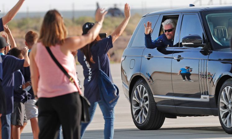 Richard Branson saluda a unos alumnos mientras se dirige a subir al avión espacial.