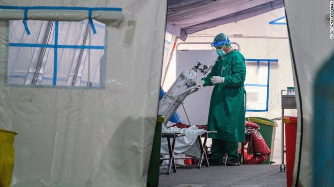 Un miembro del personal médico cambia un tanque de oxígeno en una tienda de campaña instalada en un hospital público para manejar el exceso de pacientes de covid-19 el 24 de junio de 2021 en Yakarta, Indonesia.