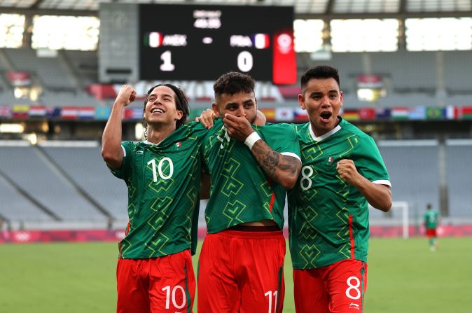 Alexis Vega, #11 del "Tri" méxicano celebra, besando su camiseta, al lado de sus compañeros Carlos Rodríguez, #8 y Diego Lainez, #10, después de anotar el primer gol de su equipo durante el partido de la primera ronda masculina de fútbol del Grupo A entre México y Francia, en la apertura de los Juegos Olímpicos de Tokio 2020.