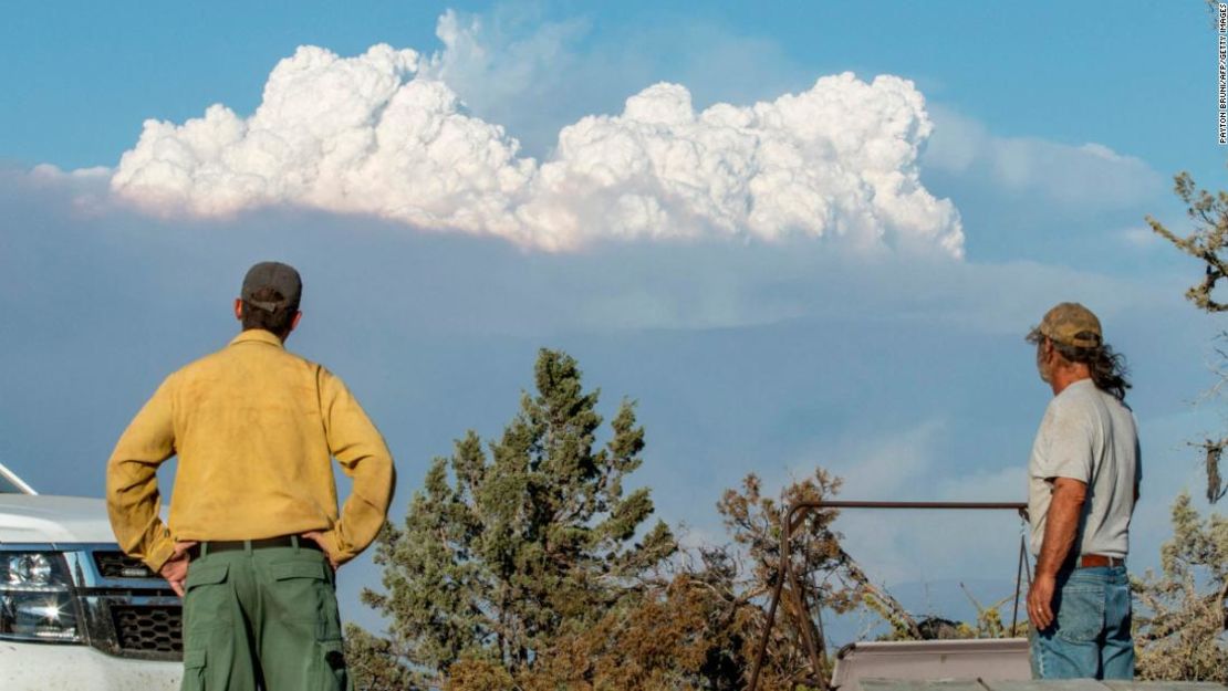 El especialista en mitigación de incendios y educación Ryan Berlin (izquierda) y Bob Dillon observan la nube de humo del incendio Bootleg desde la casa de Dillon en Beatty, Oregon, el 16 de julio de 2021.