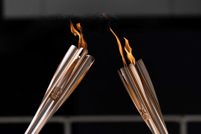 Portadores de la antorcha pasan la llama olímpica durante la ceremonia de llegada del Relevo de la Antorcha Olímpica de Tokio 2020, antes de la ceremonia de apertura de los juegos.