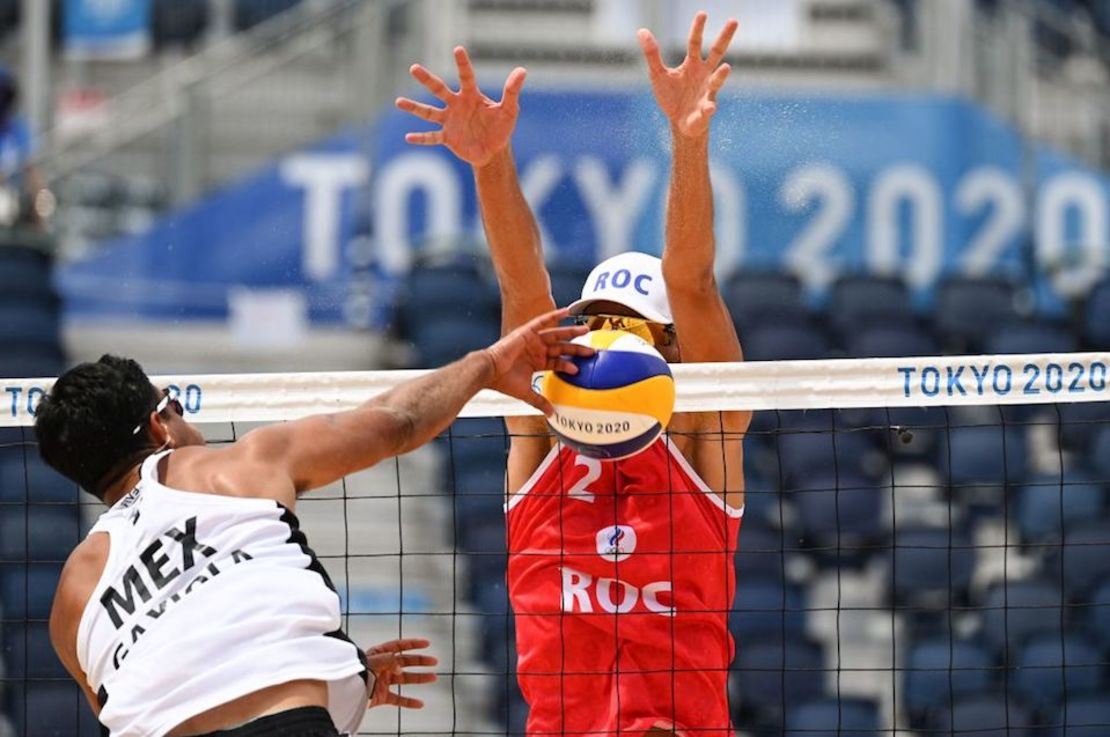 El mexicano Josue Gaston Gaxiola Leyva intenta un tiro frente al ruso Oleg Stoyanovskiy en el partido preliminar del grupo B de voleibol de playa masculino entre Rusia, identificado como ROC, y México durante los Juegos Olímpicos de Tokio 2020 en el Parque Shiokaze de Tokio el 26 de julio de 2021.