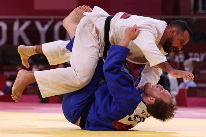 El uruguayo Alain Aprahamian (de blanco) y el sueco Robin Pacek compiten en judo en los Juegos Olímpicos de Tokio.