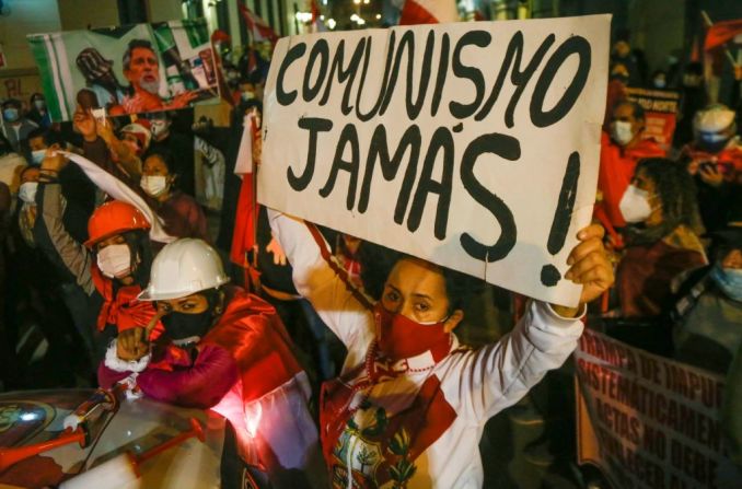 Anteriormente, otros manifestantes contrarios a Castillo, de la derecha, dicen "Comunismo jamás" frente al Palacio de Gobierno en Lima el 14 de julio de 2021.