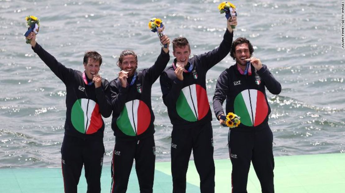 Los medallistas de bronce Matteo Castaldo, Marco di Costanzo, Matteo Lodo y Giuseppe Vicino de Italia muerden sus medallas durante la ceremonia de entrega de medallas.