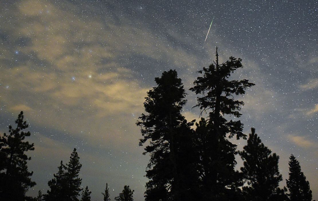 La lluvia de meteoros de las perseidas cruza el cielo por encima de los pinos del desierto el 13 de agosto de 2015 en el Área Recreativa Nacional Spring Mountains, Nevada.