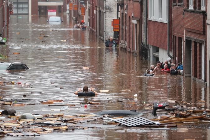 En esta imagen, mientras tanto, un grupo de personas intenta preservarse en medio de la inundación en las calles de Lieja, en Bélgica, el 15 de julio.