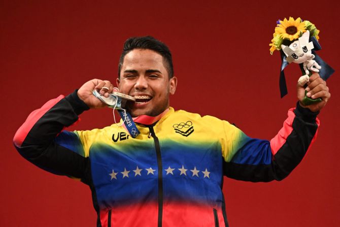 El venezolano Keydomar Giovanni Vallenilla Sánchez, medallista de plata, posa en el podio durante la ceremonia de victoria de la competencia de halterofilia masculina de 96 kg durante los Juegos Olímpicos de Tokio 2020, en el Foro Internacional de Tokio el 31 de julio de 2021.