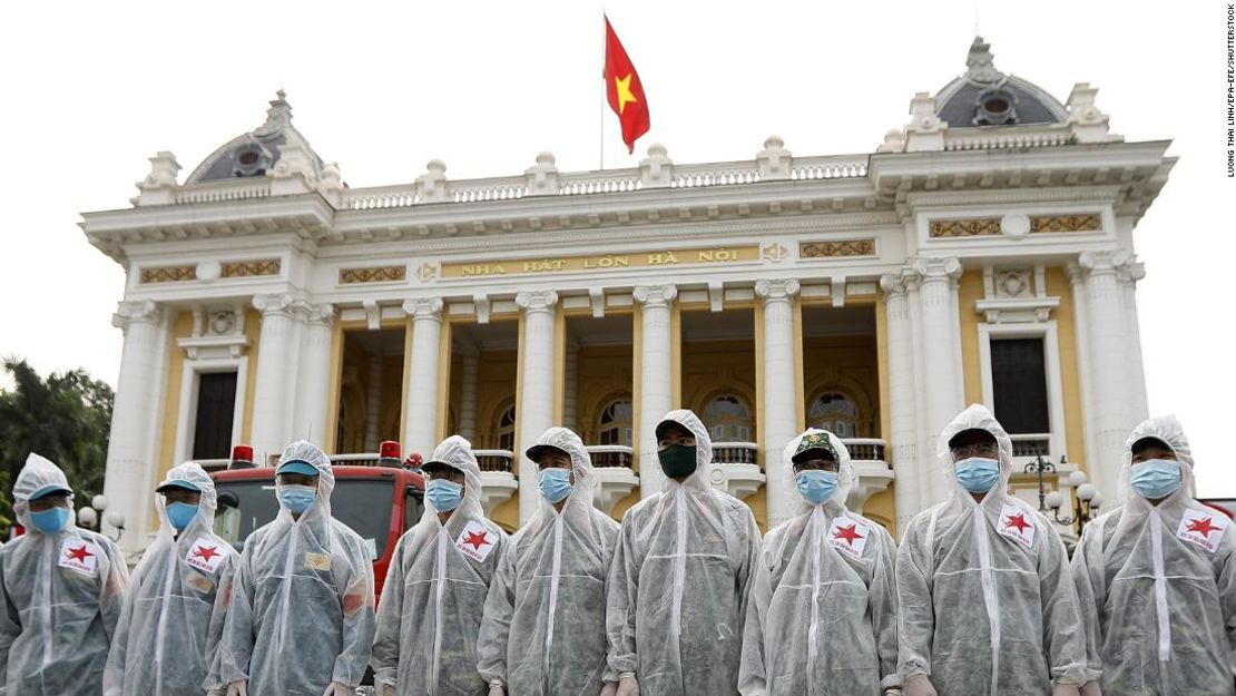 Soldados del Alto Mando de Productos Químicos del Ministerio de Vietnam Defensa Nacional antes de rociar desinfectante en las calles de Hanoi el 26 de julio.