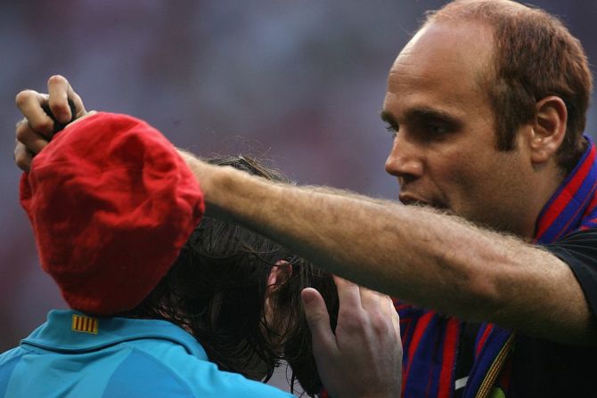 Un fan del Barcelona se mete al campo de juego para darle una gorra a Messi durante un partido contra el Bayern Munich en agosto de 2007.
