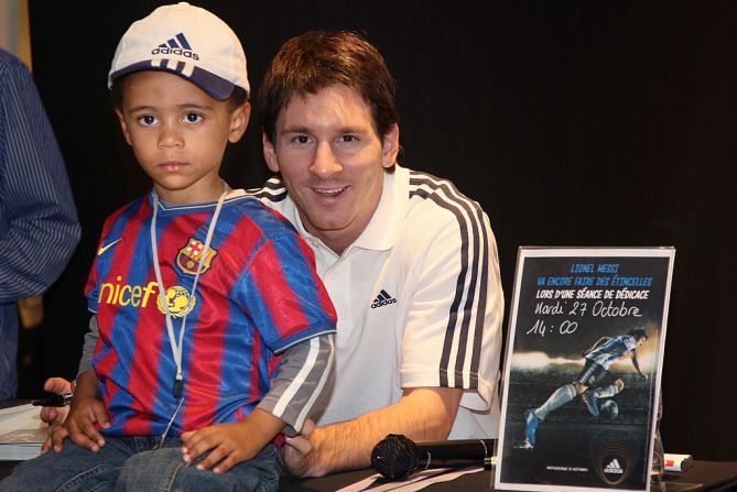 Messi posa con un niño durante una sesión de dedicatorias en octubre de 2007.