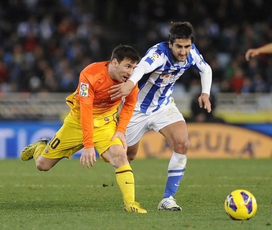 Markel Bergara del Real Sociedad, lucha por la pelota ante Messi durante un partido de la Liga Española en enero de 2013.