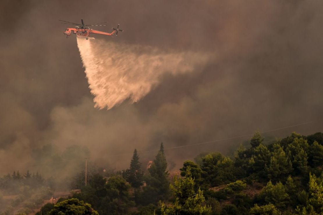 Un helicóptero intenta apagar un incendio en el área cerca de Agios Stefanos, en el norte de Atenas el 6 de agosto de 2021.