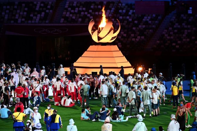 Deportistas celebran junto al pebetero y el fuego olímpicos durante la ceremonia de clausura de Tokio 2020, en el Estadio Olímpico, en Tokio, el 8 de agosto de 2021.