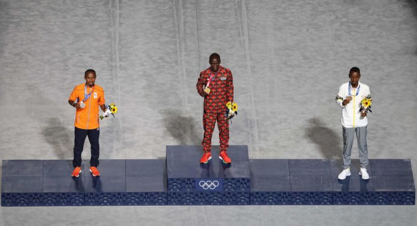 (De izquierda a derecha), el medallista de plata de Países Bajos, Abdi Nageeye; el medallista de oro de Kenia, Eliud Kipchoge; y el medallista de bronce de Bélgica, Bashir Abdi, suben al podio durante la ceremonia de entrega de medallas del maratón masculino, celebrada durante la ceremonia de clausura de los Juegos Olímpicos de Tokio 2020, el 8 de agosto de 2021 en el Estadio Olímpico de Tokio.