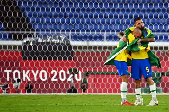 Dani Alves y Douglas Luiz, celebran su medalla de oro tras vencer a España 2-1 en la final de fútbol masculino.