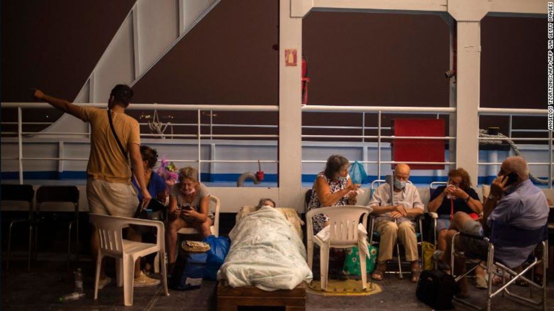 Ancianos en sillas y camas improvisadas a bordo de un ferry en el puerto de la aldea de Pefki, durante un incendio forestal en la aldea de Pefki en Evia.