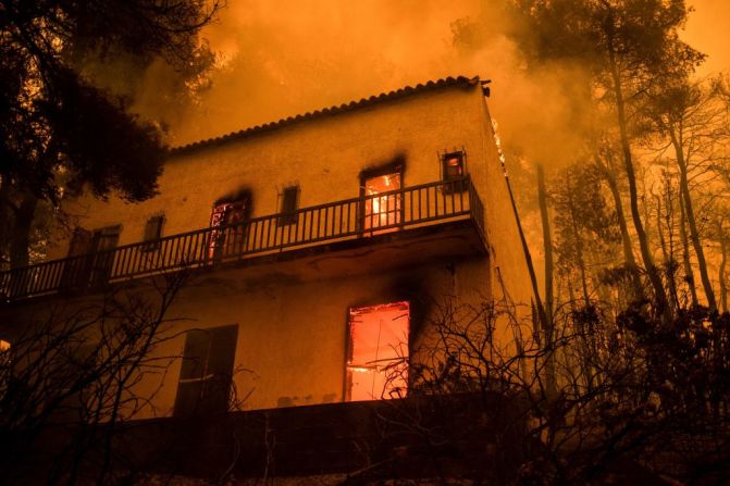 Una casa arde en la isla de Evia. El fuego obligó a la evacuación de turistas y residentes de toda la zona.