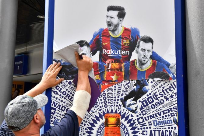 Trabajadores retiran un poster de Messi en el Camp Nou, en Barcelona.