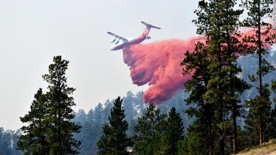 Un avión lanza retardante de fuego para frenar la propagación del incendio de Richard Spring, al este de Lame Deer, Montana, el miércoles 11 de agosto de 2021. El incendio se extendió rápidamente el miércoles cuando los fuertes vientos empujaron las llamas a través de un terreno boscoso y accidentado.