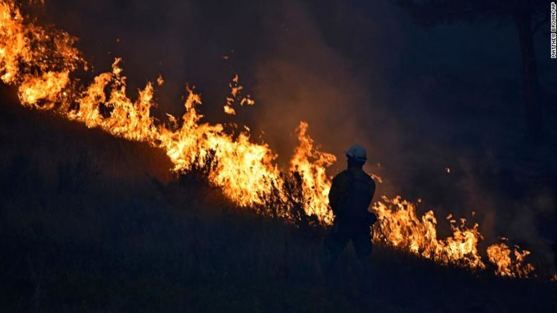 Un bombero se encuentra junto al borde del incendio forestal que arde en la reserva india de Cheyenne del Norte, el 11 de agosto de 2021.